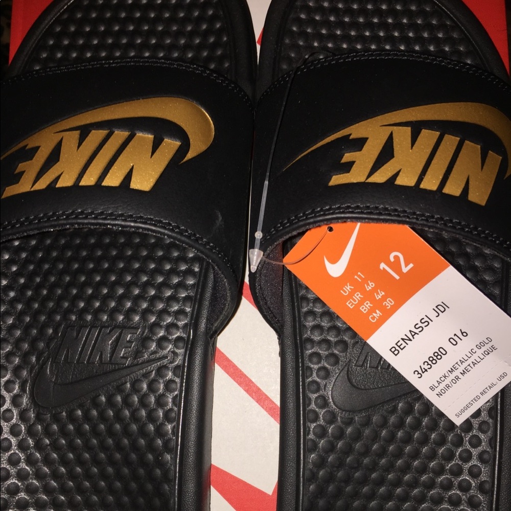 Gold and black nike benassi slides